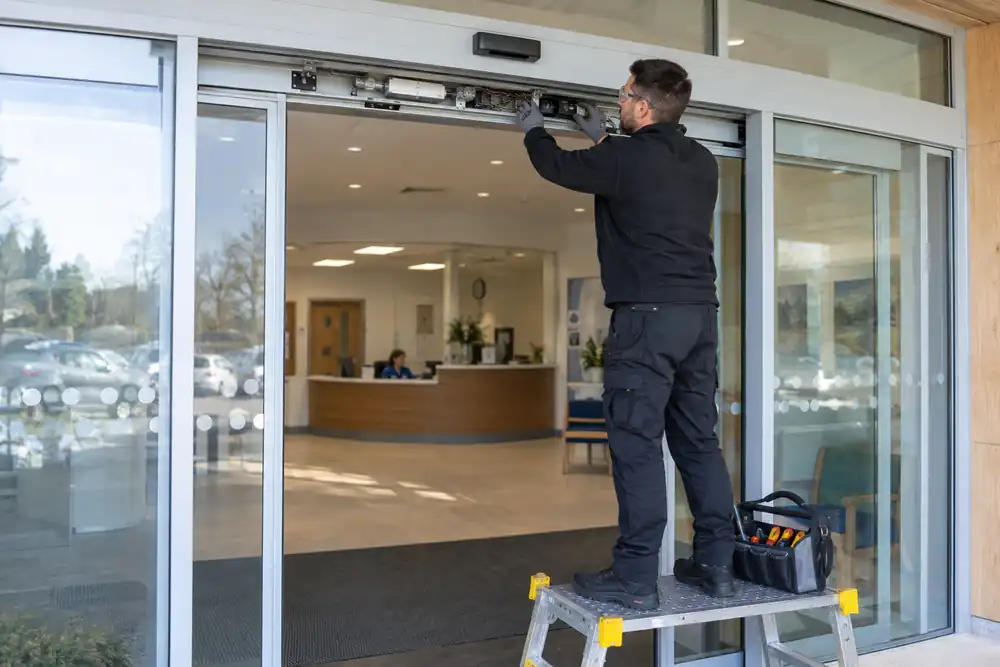 Technician inspecting automatic sliding glass shopfront doors